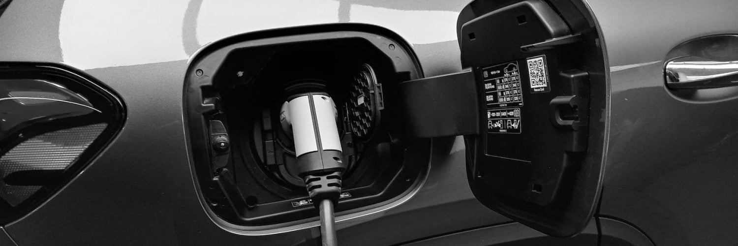 monochrome photo of hybrid car charging
